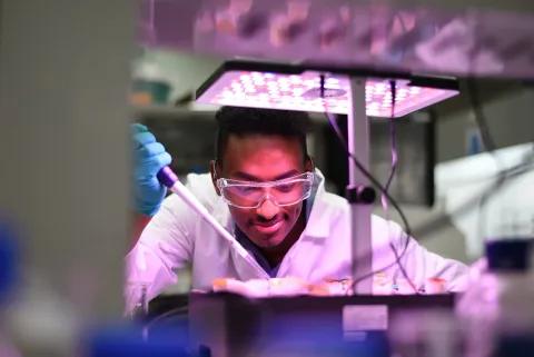 Researcher conducting sustainable energy experiments in a DTV lab